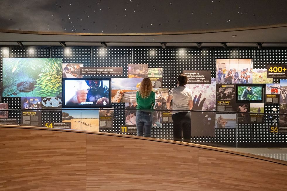 Two people observing a photo exhibit at the National Geographic Museum of Exploration