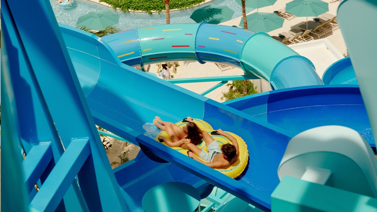 Two people on a yellow raft slide down a blue water slide at Great Tides Waterpark