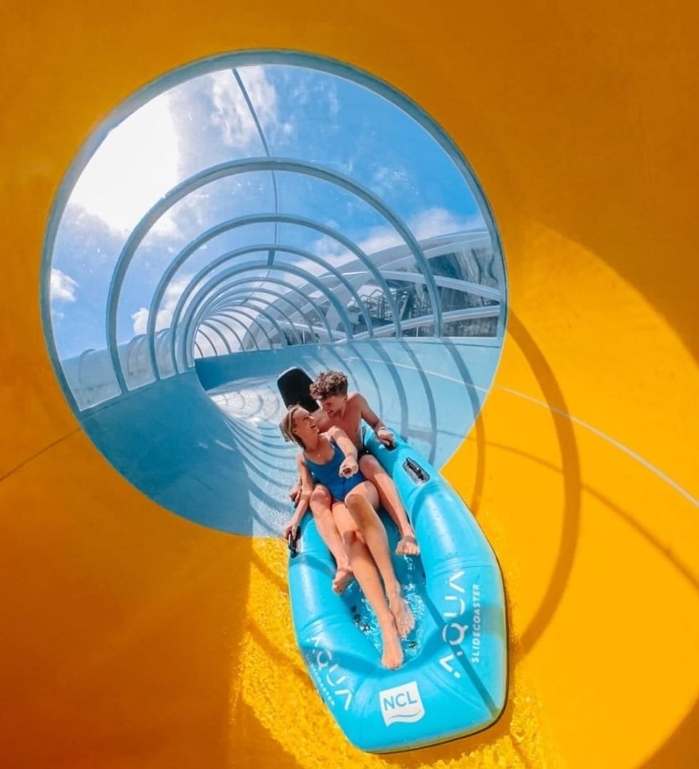 Two people ride the Slide Coaster on a sunny day.