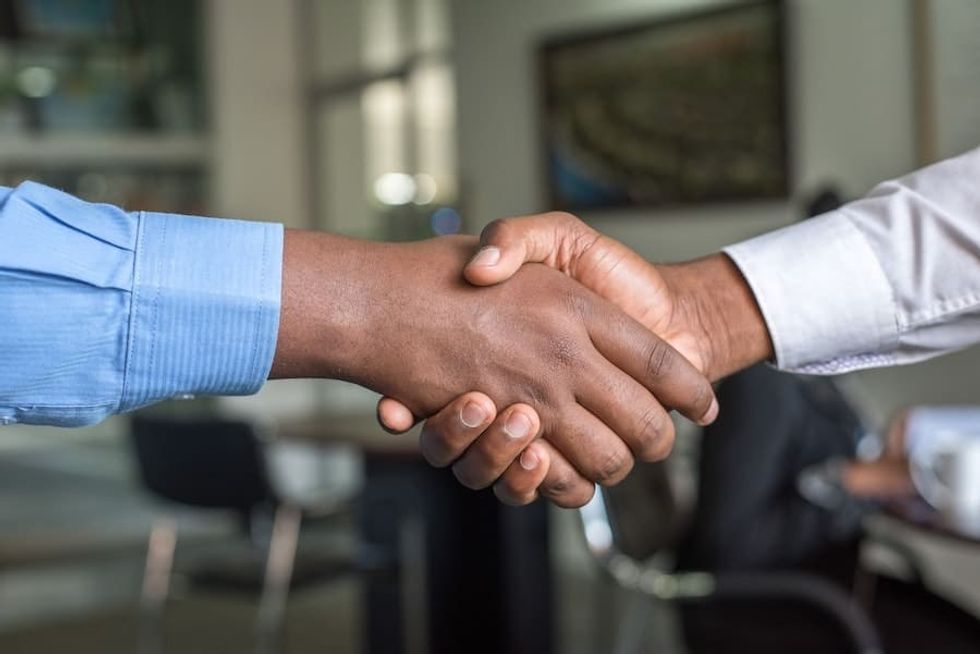 two people shaking hands - trust is essential in a remote work setup Hiring after covid