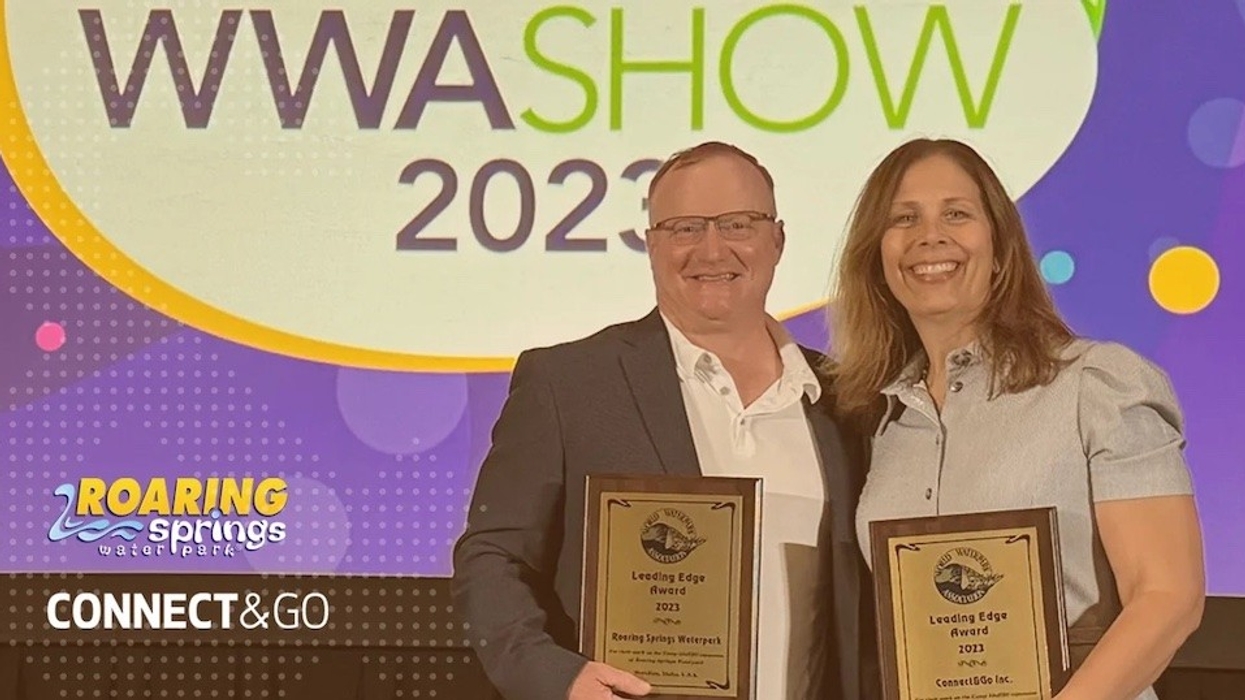 Two people standing with a Leading Edge Award 2023