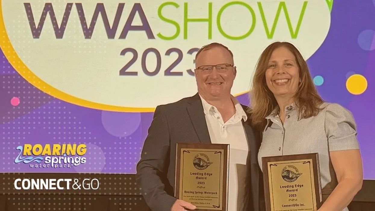 Two people standing with a Leading Edge Award 2023