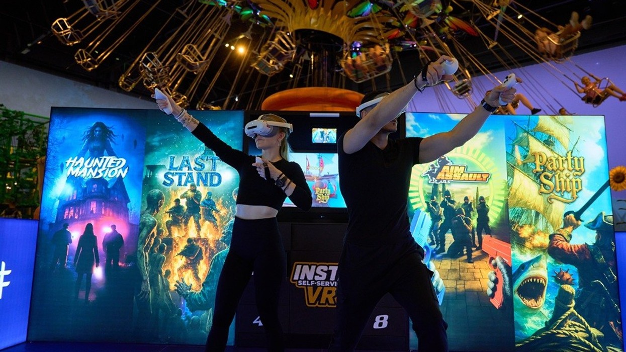 Two people using VR headsets and controllers in a gaming arcade.