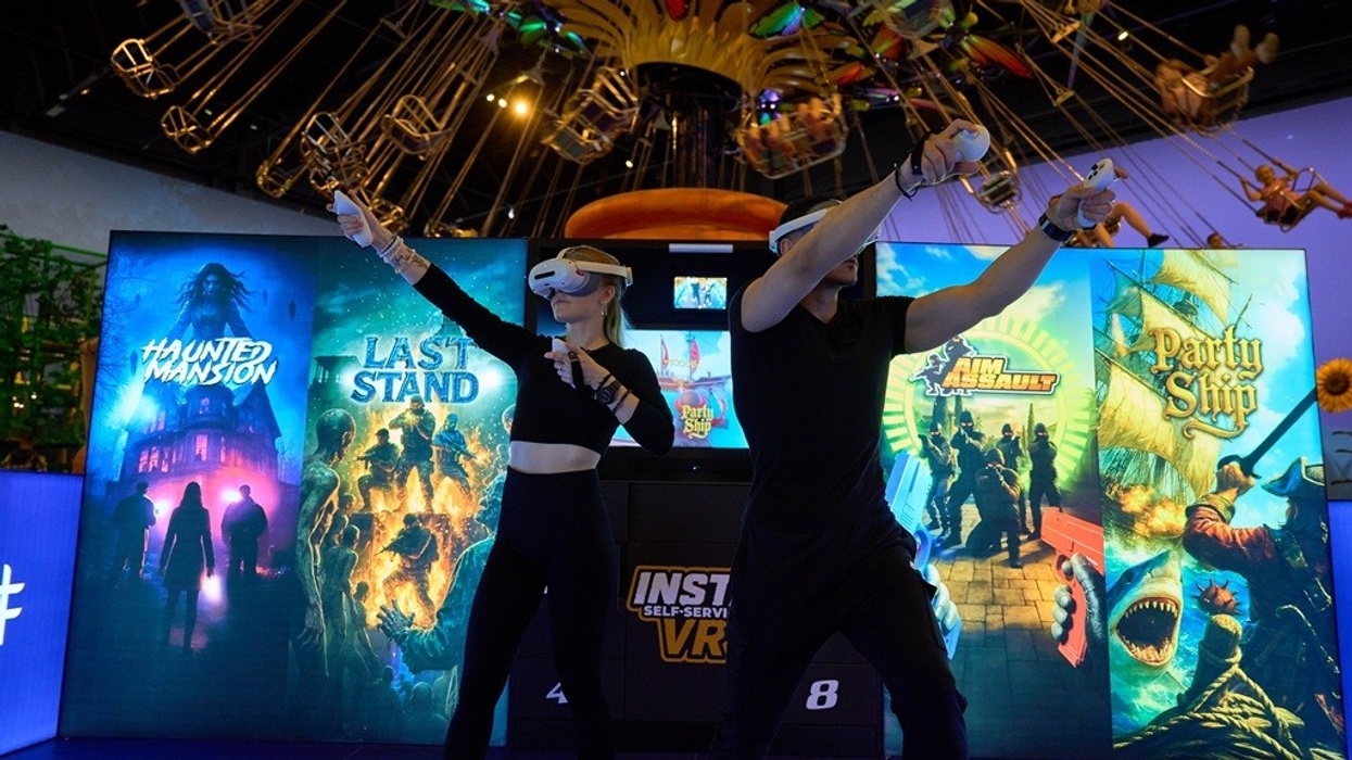 Two people using VR headsets and controllers in a gaming arcade.