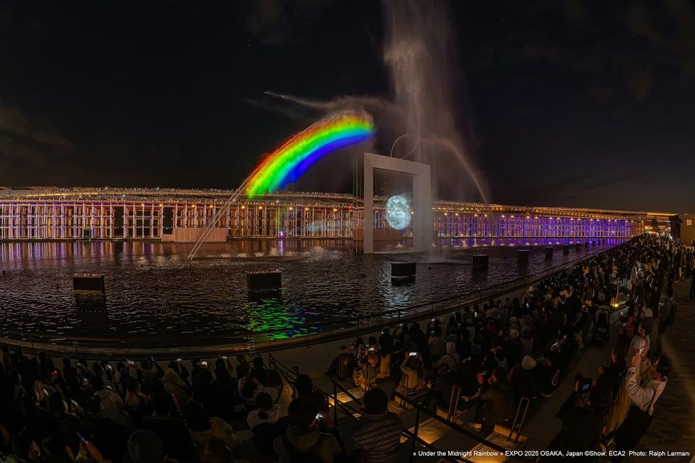Under The Midnight Rainbow ECA2 Nighttime rainbow and light show over a fountain, attended by a large crowd.
