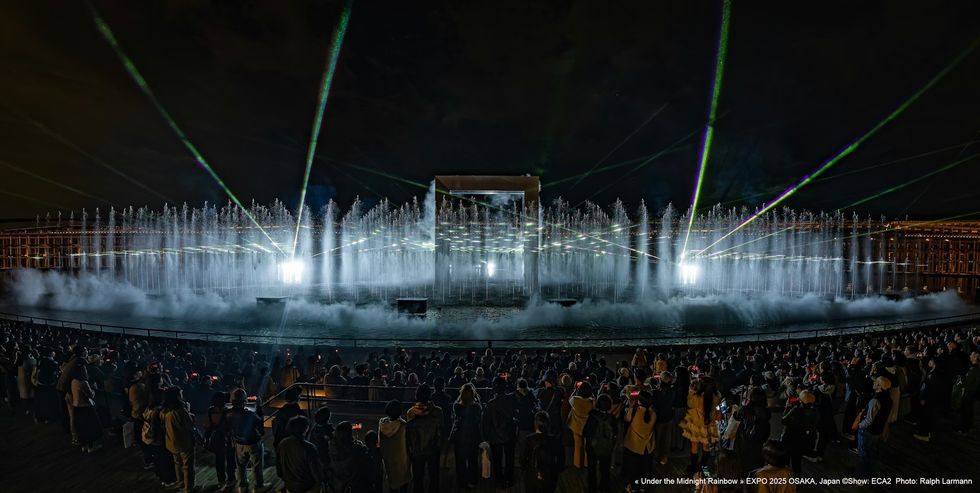 Under The Midnight Rainbow ECA2 Nighttime water and light show with fountains and lasers, viewed by a large crowd.