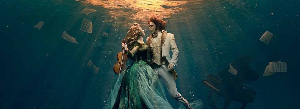 Underwater dance with a violinist, pianist, and scattered sheet music.