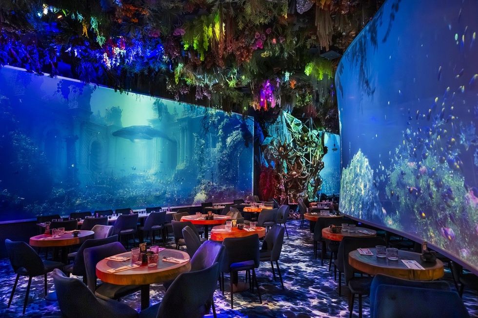 Underwater-themed restaurant with vibrant marine decor and colorful ceiling lights.