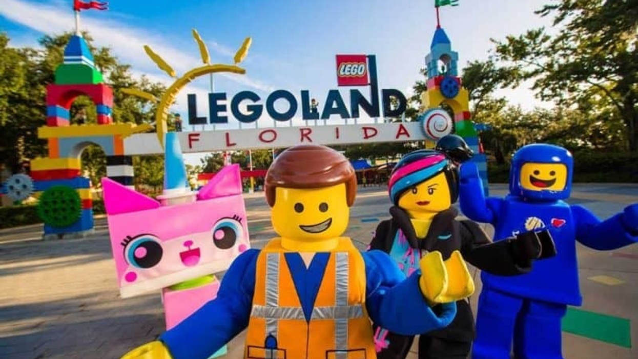Unikitty, Emmet, Wyldstyle and Benny from THE LEGO MOVIE WORLD posing in front of Legoland Florida entrance