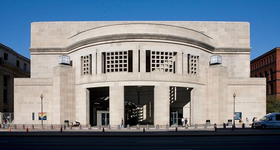 United States Holocaust Memorial Museum - Modern stone museum facade with arched windows and entrance on a sunny day.