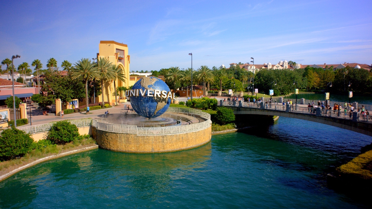 Universal Studios entrance with iconic globe sculpture, surrounded by water and lush greenery.