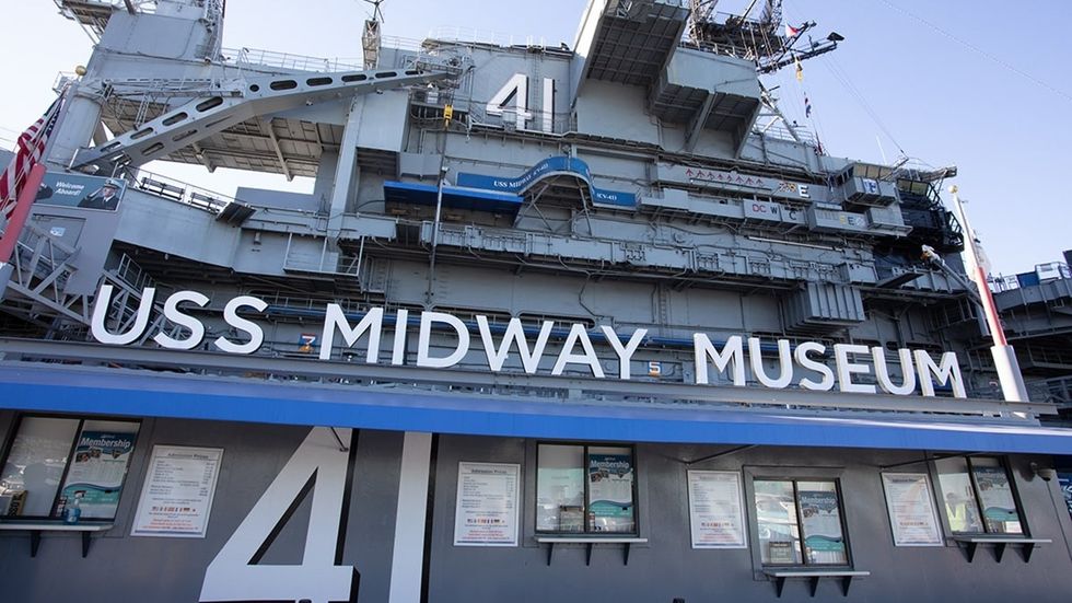 USS Midway Museum exterior with ship's structure and large signage visible.