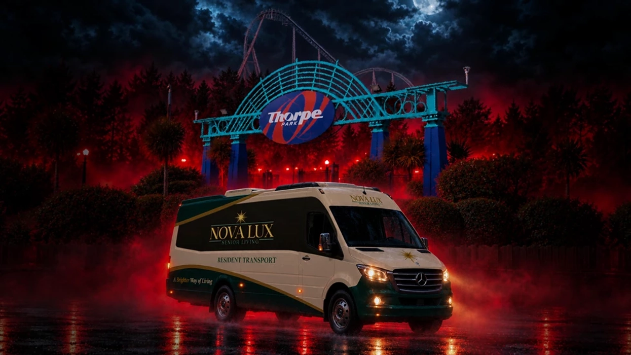 Van in front of Thorpe Park entrance at night with dramatic lighting.