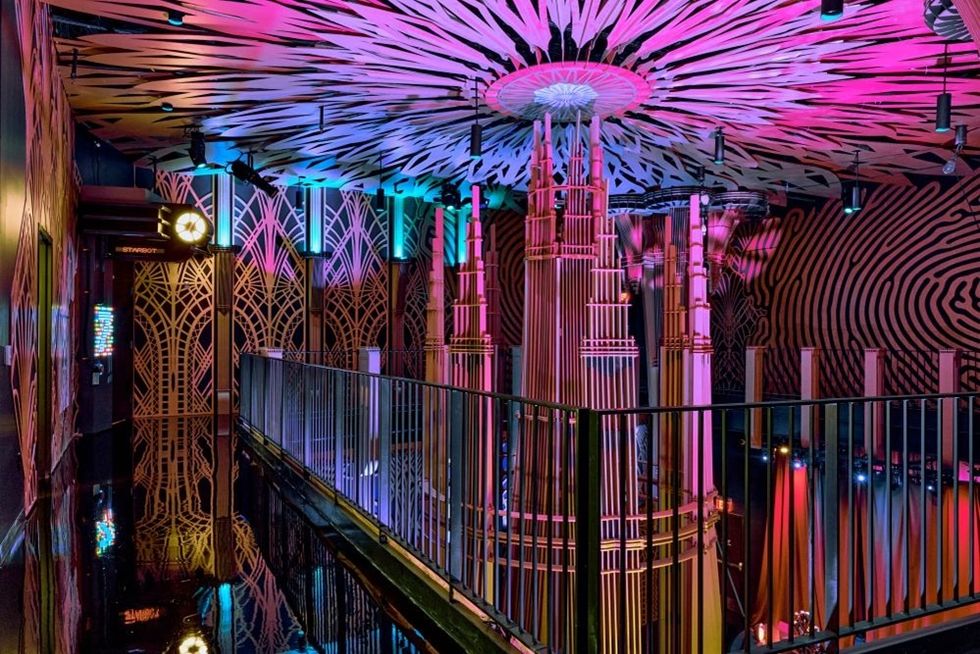 Vibrant art deco interior with colorful lighting and intricate geometric patterns.