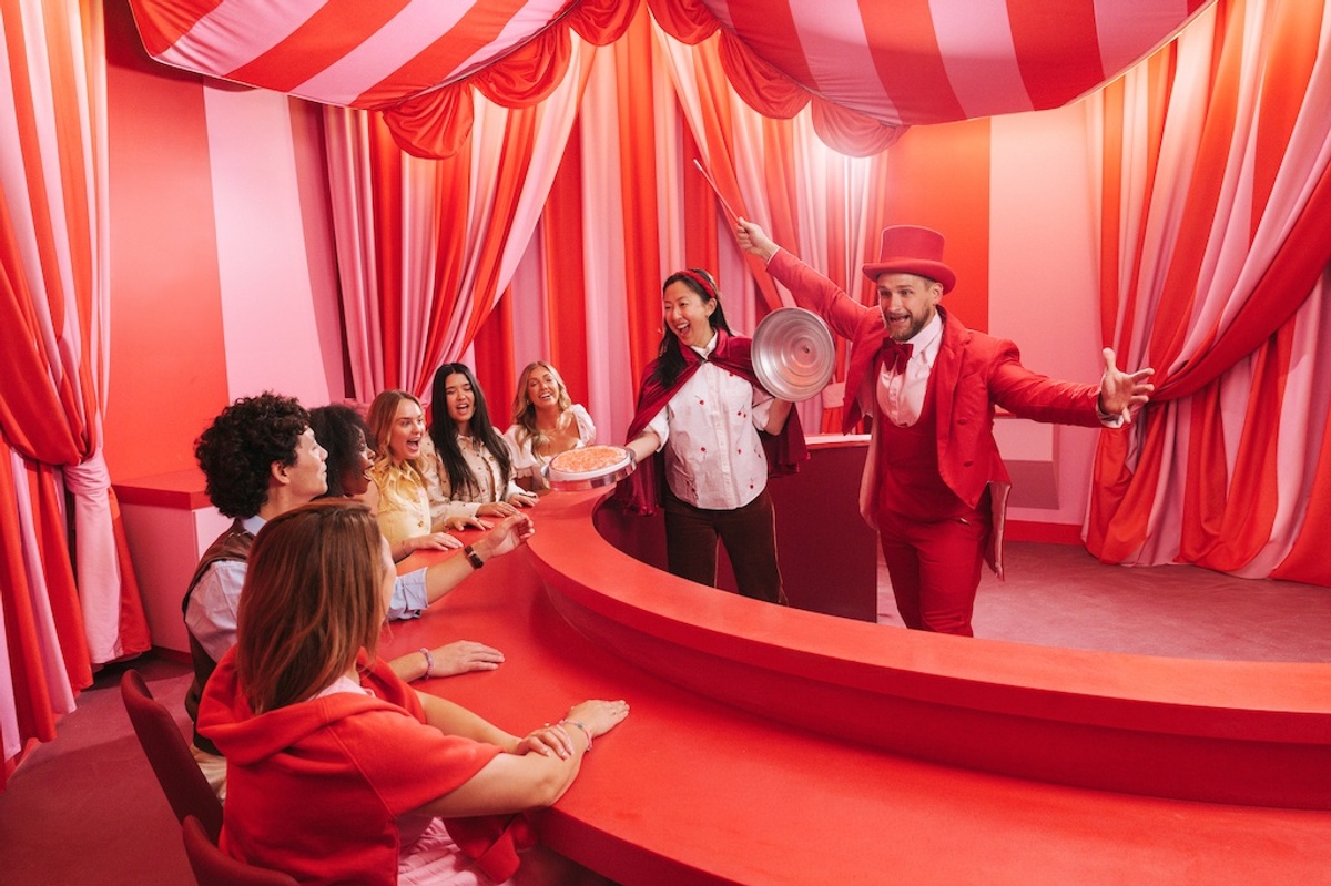 Vibrant circus-themed room with performers entertaining a seated audience, Museum of Ice Cream