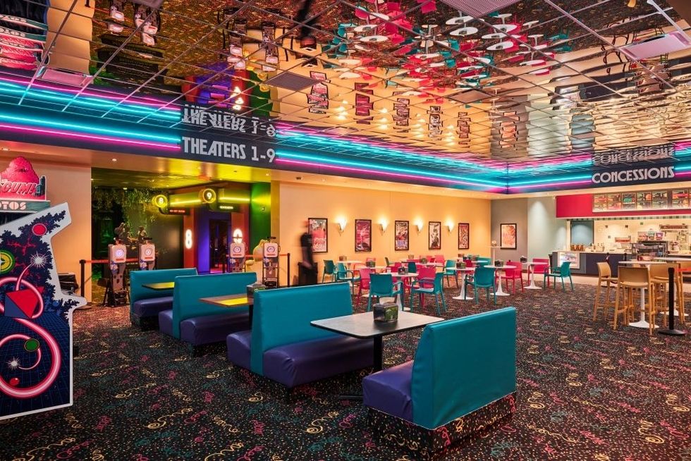 Vibrant retro-style movie theater lobby with colorful seating and neon lights.