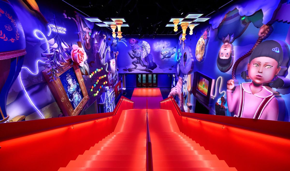 Vibrant, surreal hallway with red stairs and colorful murals on both walls.