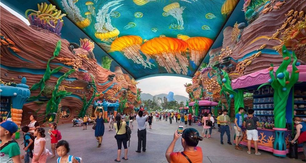 Vibrant theme park called Chimelong Icean Kingdom walkway with colorful oceanic decor and ceiling mural.