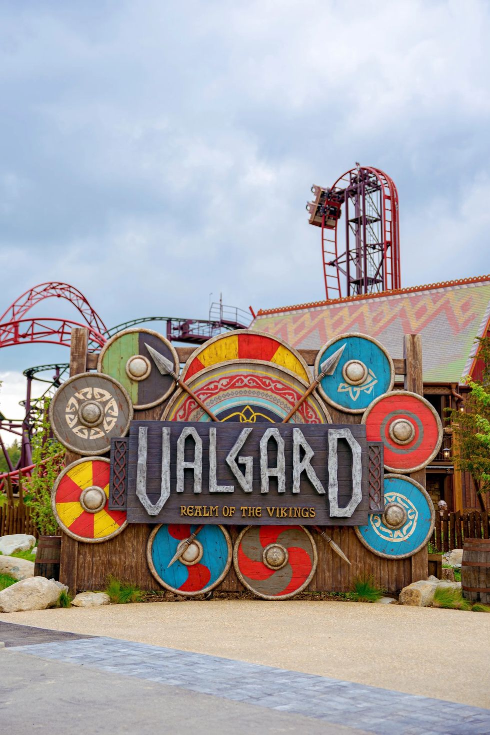 Viking-themed amusement park entrance with colorful shields and roller coaster track.