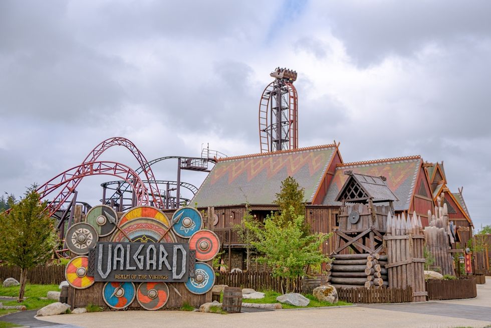 Viking-themed amusement park with roller coaster and rustic buildings.