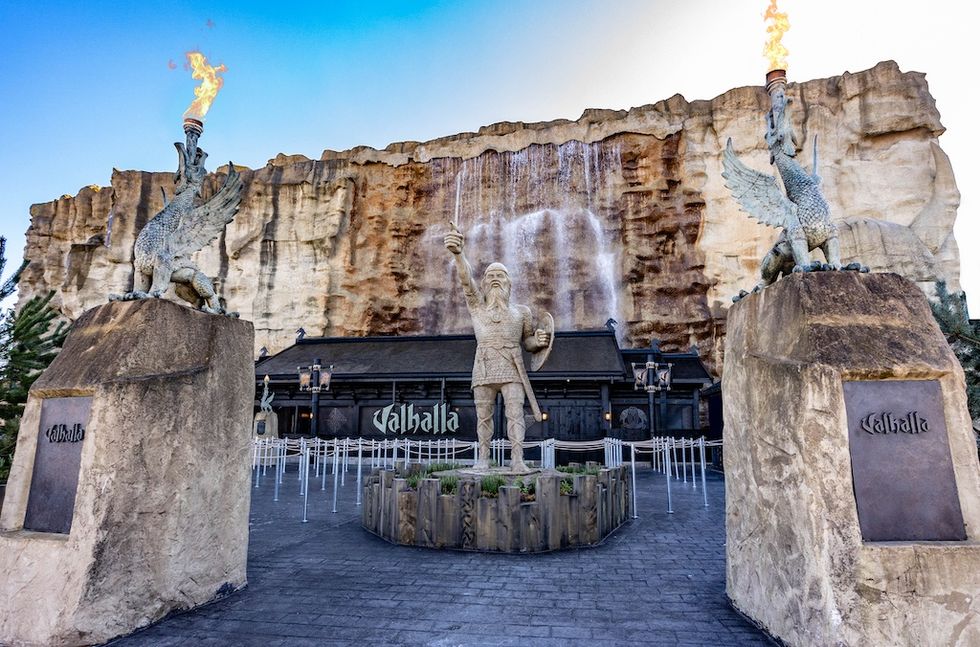Viking-themed entrance with statues and cascading waterfall backdrop.