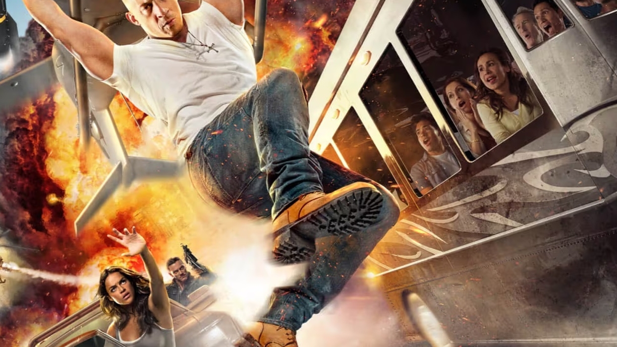 Vin Diesel hanging from a vehicle with explosion in the background, people inside train reacting.