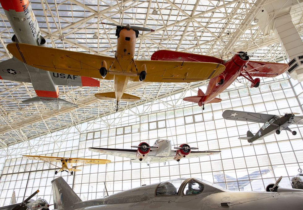 Vintage airplanes suspended in a large, sunlit aviation museum called the Museum of Flight