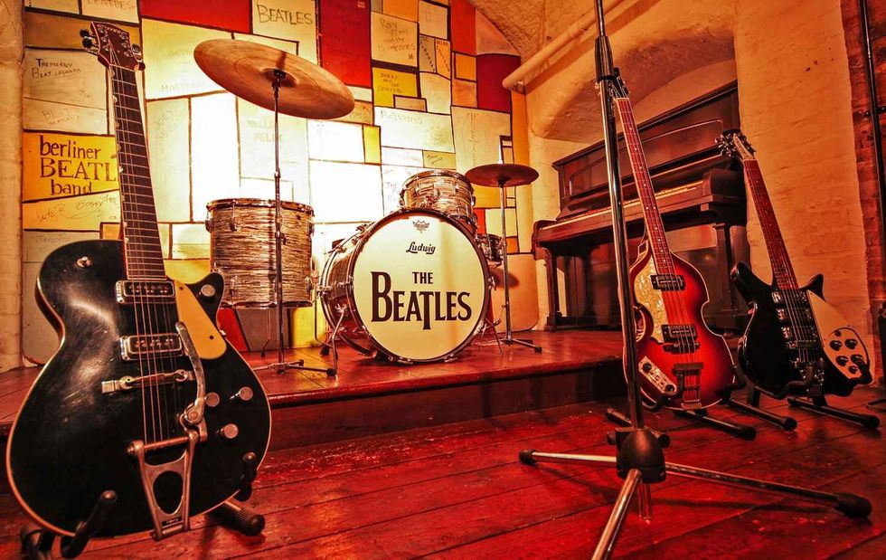 Vintage Beatles stage setup with guitars, drum kit, and piano at The Beatles Story Liverpool