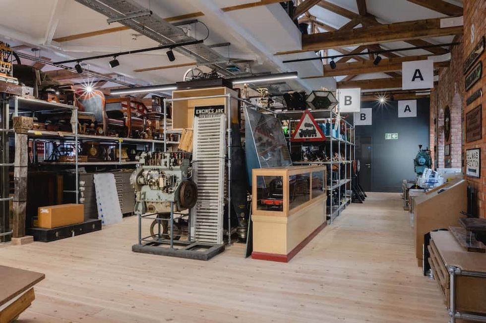 Vintage machinery and signage displayed in an industrial-style room with wooden beams at the Museum of Making, Derby.
