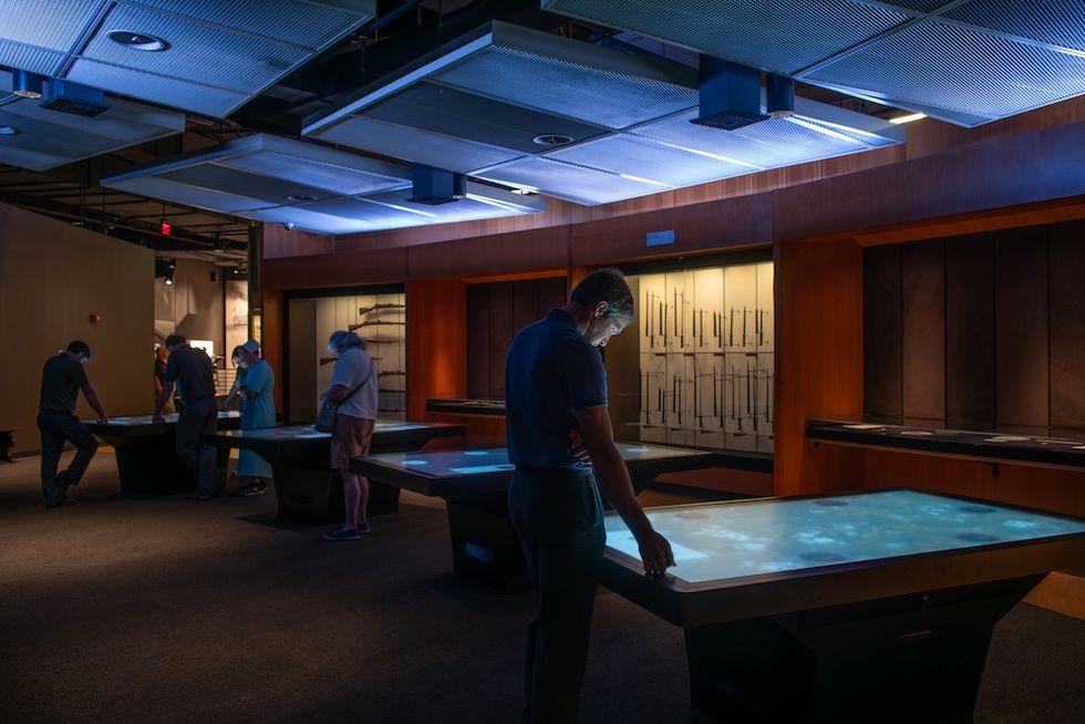 Visitors interact with illuminated touch tables at the National WWI Museum and Memorial