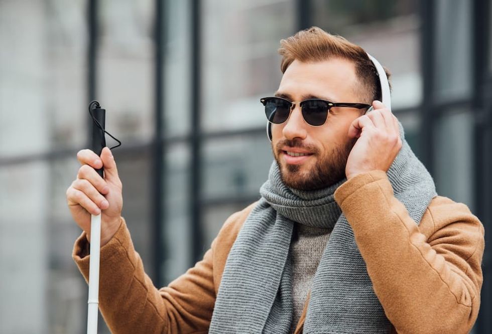 visually-impaired-person-with-stick-and-headphones