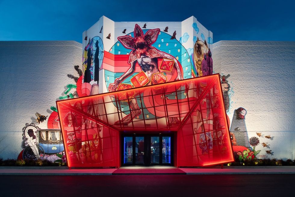 Vivid mural and red geometric entrance of a building at night.