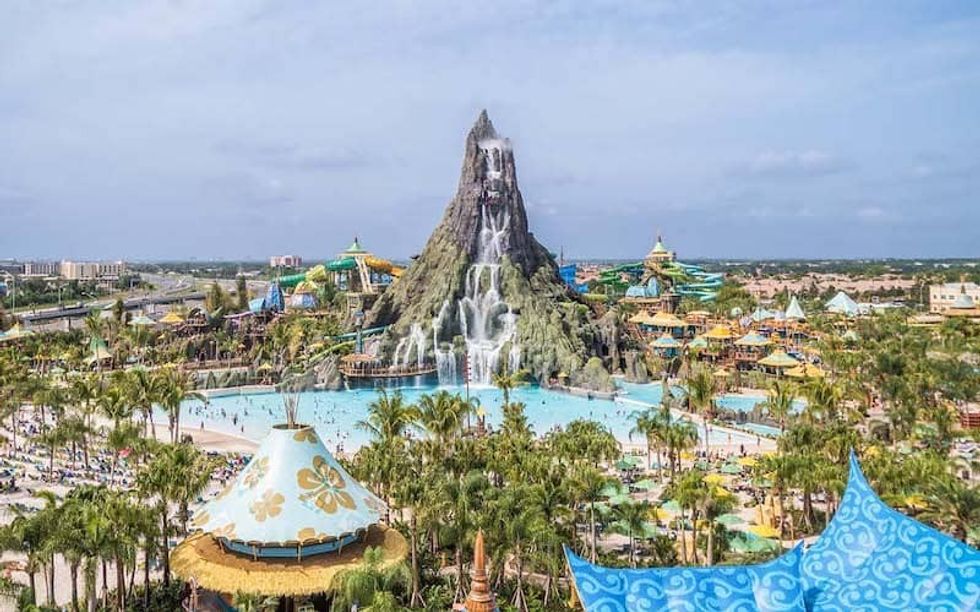 Volcano Bay water park with a tall volcano slide, pools, and colorful structures surrounded by palm trees