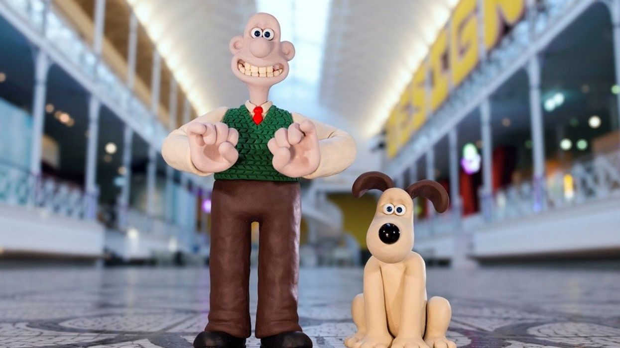 Wallace and Gromit on a tiled floor in a bright, arched indoor space.