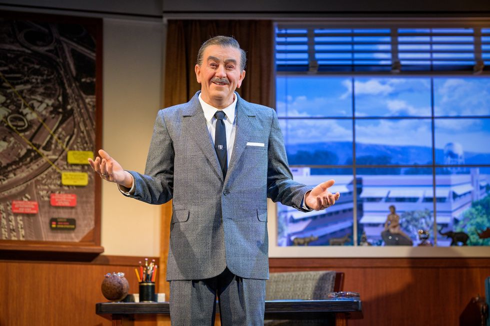 Walt Disney animatronic in a suit gesturing in an office with a map and window backdrop, part of Walt Disney - A Magical Life experience at Disneyland Resort.