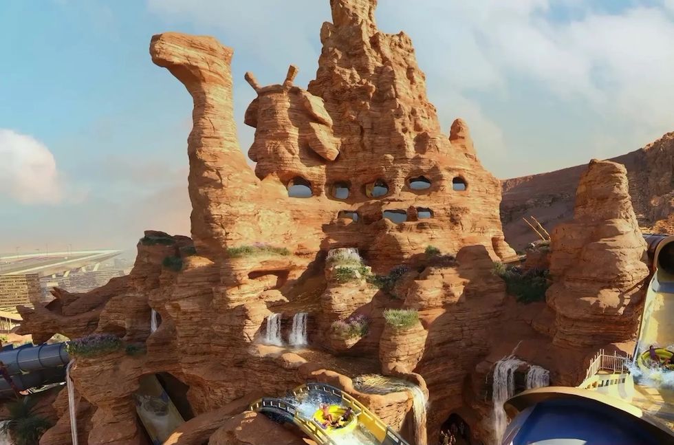 Water coaster winds through a rocky, desert-themed landscape with waterfalls and tunnels at Aquarabia