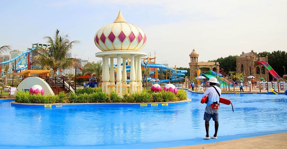 Water park with slides, decorative domes, and a lifeguard by the pool at Montazah Parks