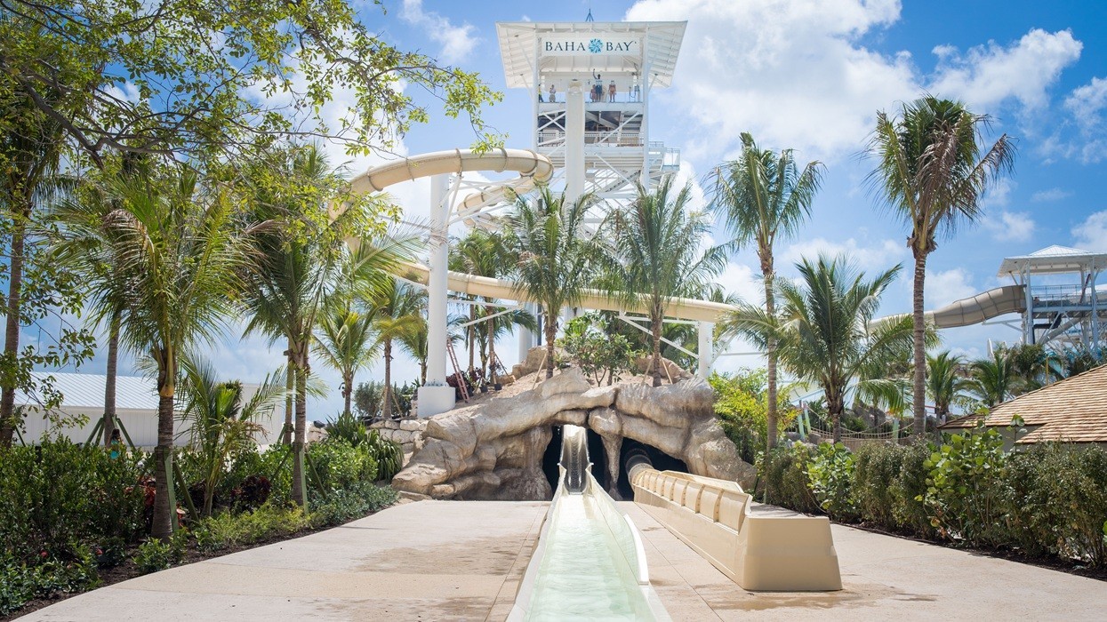 Water slide at Baha Bay water park, surrounded by palm trees and blue sky.