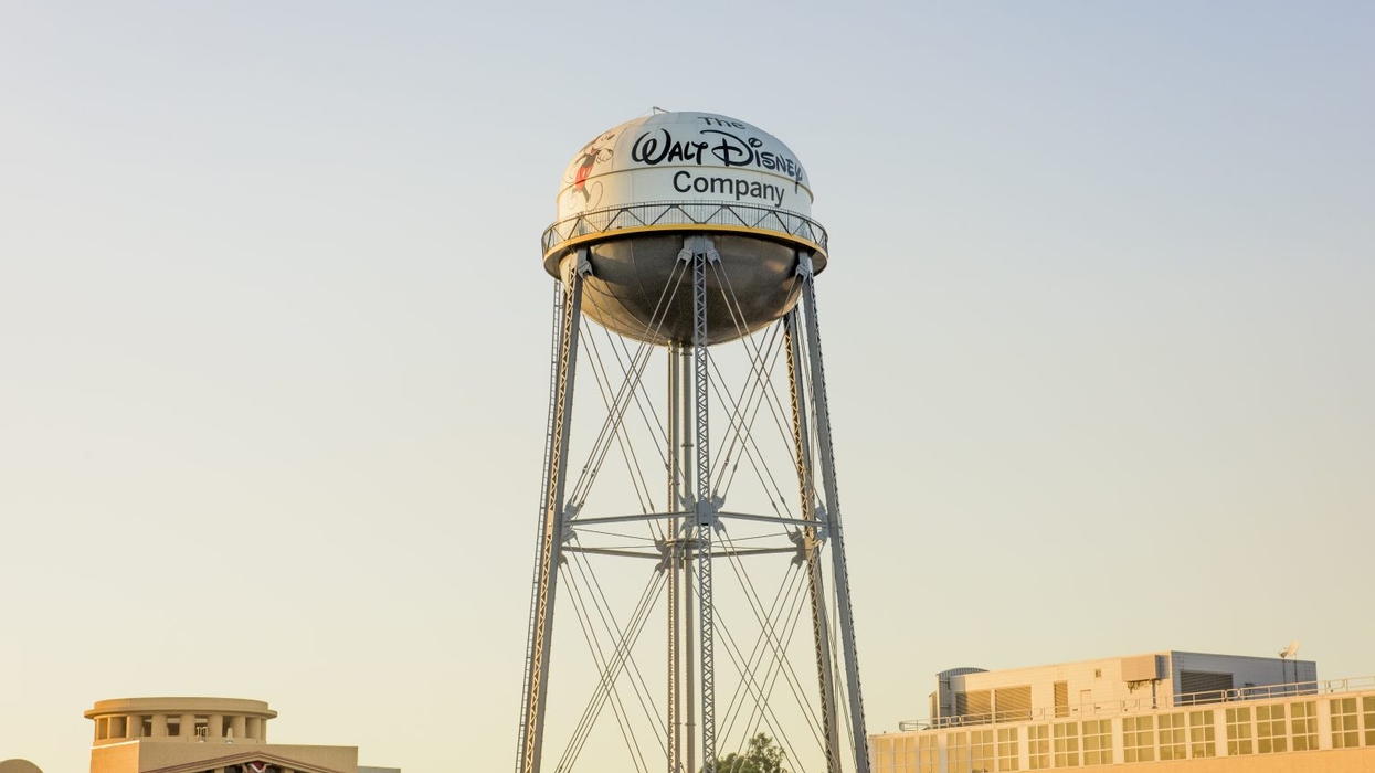 Water tower with "Walt Disney Company" logo against a clear sky.