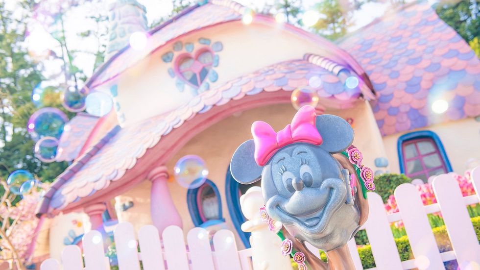 Whimsical pink cartoon house with a character statue surrounded by bubbles at Tokyo Disneyland