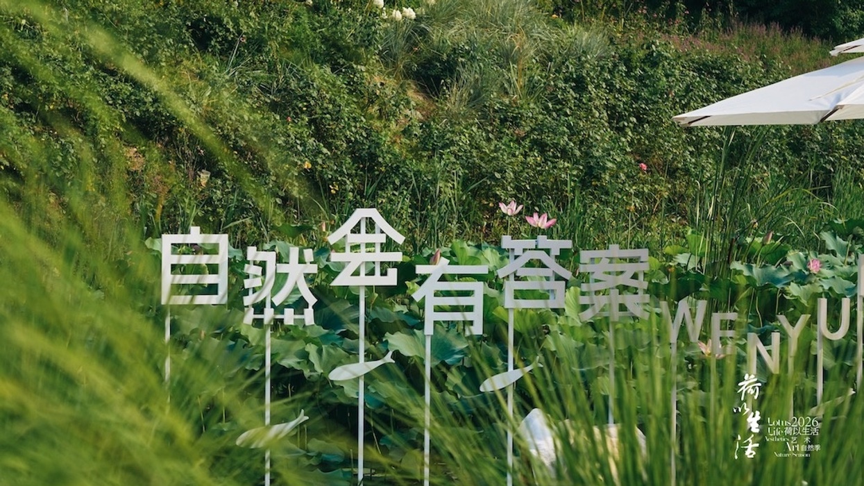 White text in a lush garden with lotus flowers and green plants.