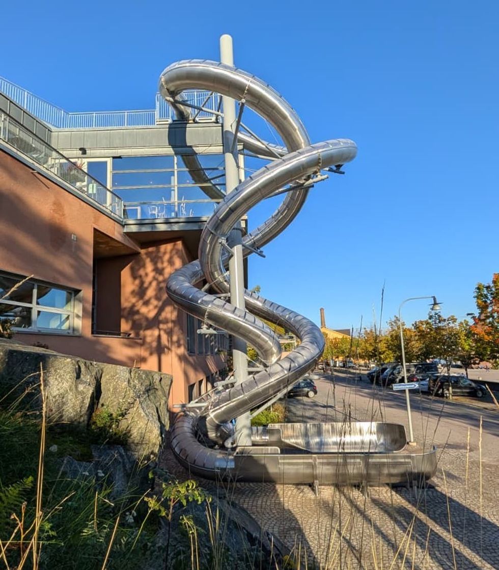 Wiegand's wisting metallic slide outside Moderna Museet on a clear sunny day.