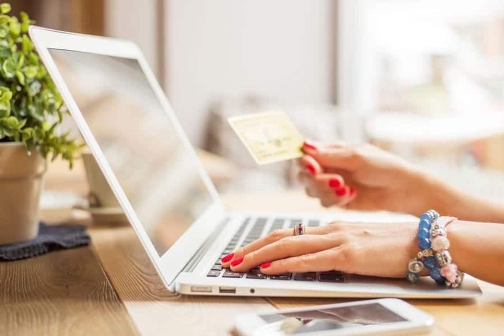 Woman holding a credit card and using her laptop