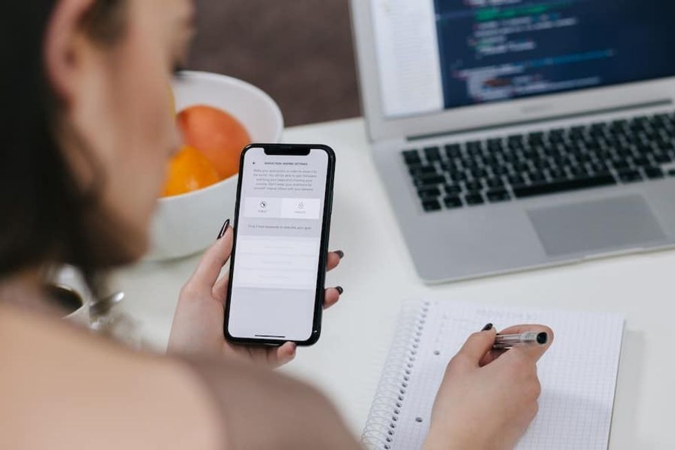 woman holding phone - clear communication is key with remote work