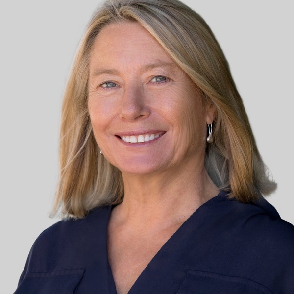 Woman in blue top against grey background