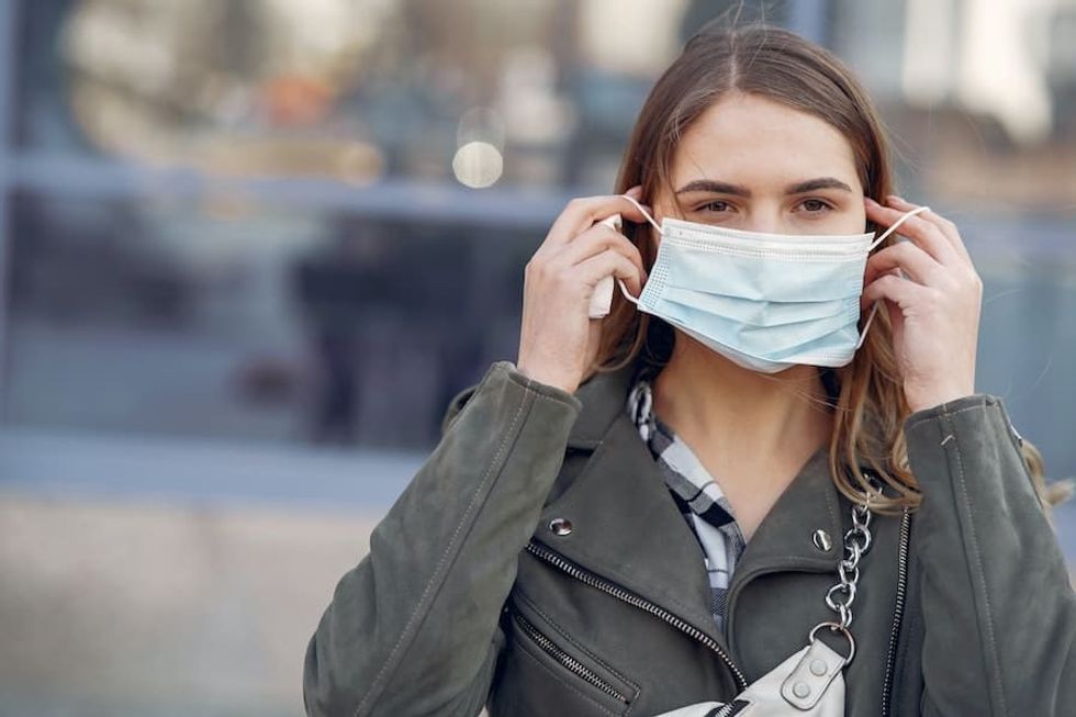 woman in face mask - will masks become the norm as coronavirus impacts the attractions industry in the future