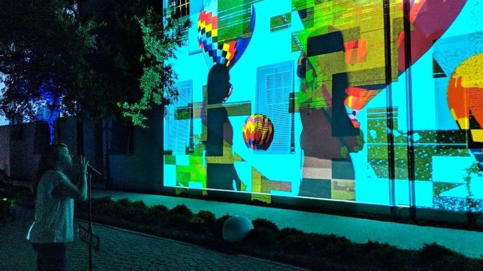 woman interacts with participation projection mapping by aoa