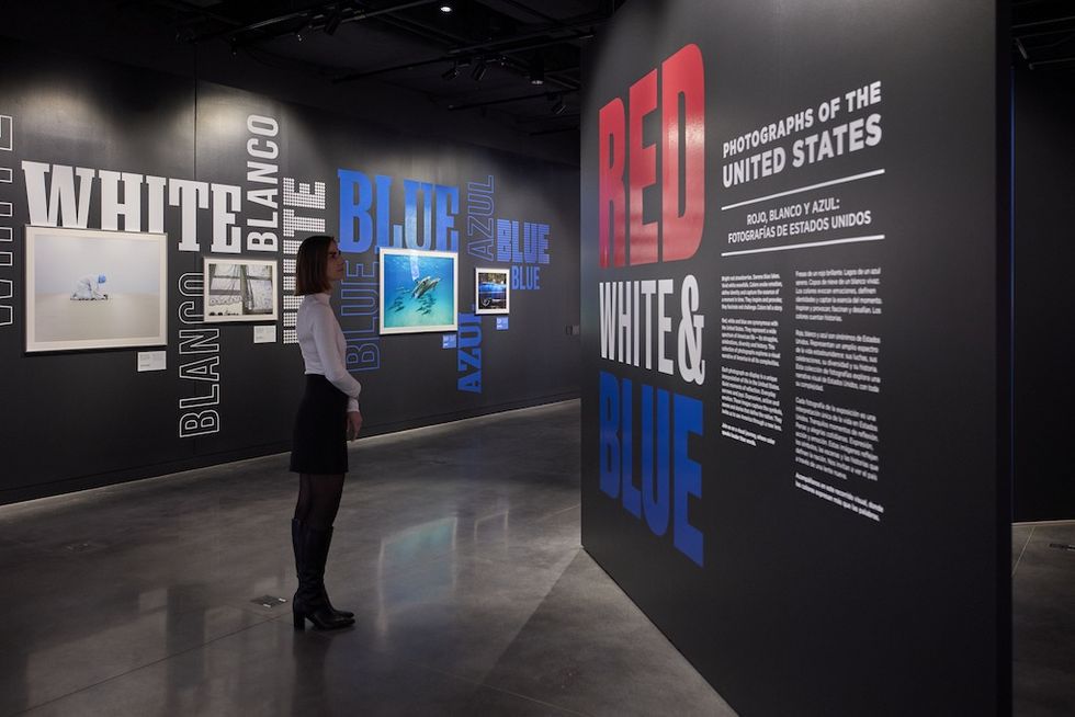 Woman observing "Red White & Blue" photo exhibit in a gallery at National Geographic's Museum of Exploration