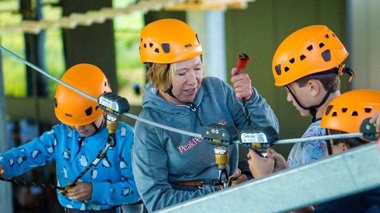 woman securs saferoller belay system at aspen-antwerpen indoor ski resort