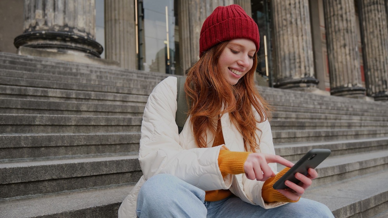 Woman sits on gallery steps looking at phone Conversational commerce